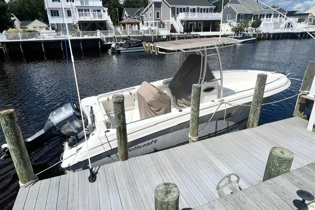 Slide: The Image of 2004 Wellcraft 252 Fisherman boat docked by waterfront homes. - 1