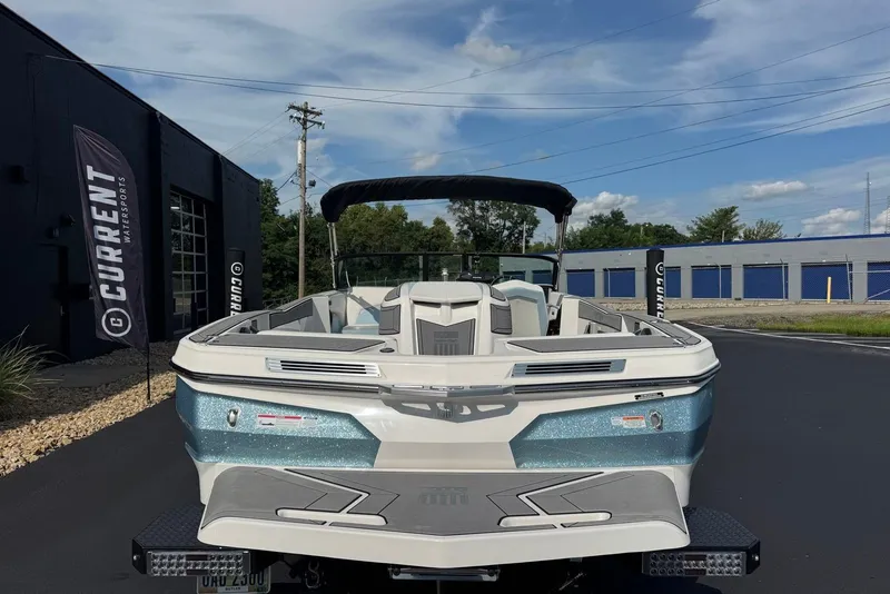 Slide: The Image of 2023 MasterCraft ProStar boat displayed outdoors at Current Watersports dealership. - 12