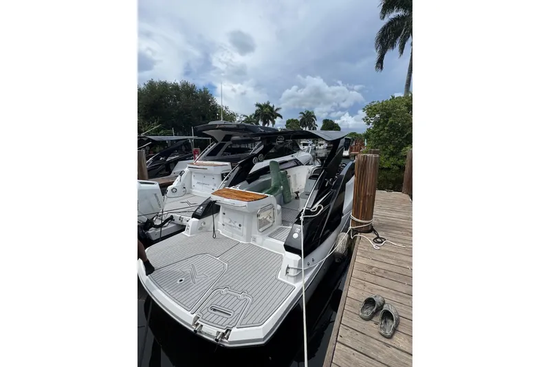 Slide: The Image of 2024 NX Boats NX280 XTREME docked, showcasing sleek design and spacious deck. - 2