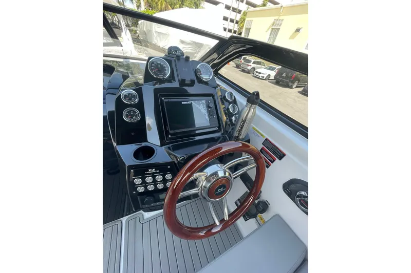 Slide: The Image of 2024 NX Boats NX280 XTREME dashboard with steering wheel and navigation controls. - 9