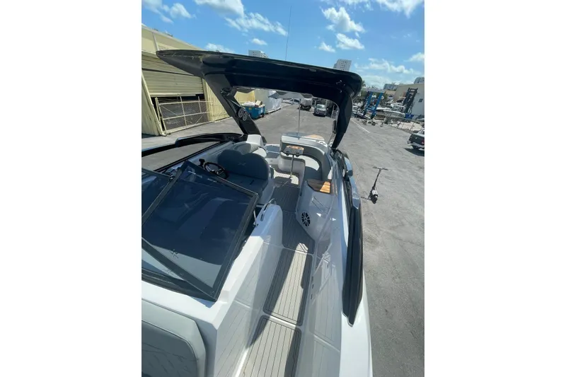 Slide: The Image of 2024 NX Boats NX280 XTREME, sleek design, docked under clear blue sky. - 6