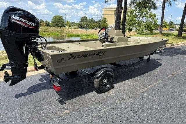 The Image of 2027 Tracker Grizzly 1648 SC boat with Mercury engine on trailer, parked outdoors. - 0