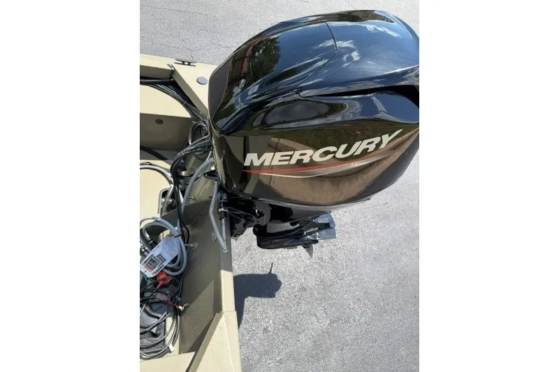 Slide: The Image of 2027 Tracker Grizzly 1648 SC boat with Mercury outboard motor, parked on pavement. - 38
