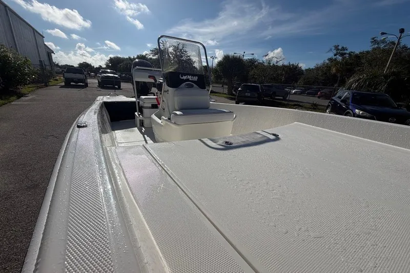 Slide: The Image of 2027 Mako Pro Skiff 17 CC boat with center console, parked outdoors under a clear sky. - 9