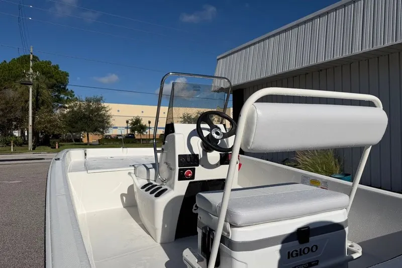 Slide: The Image of 2027 Mako Pro Skiff 17 CC boat with console and seating, parked outdoors. - 7