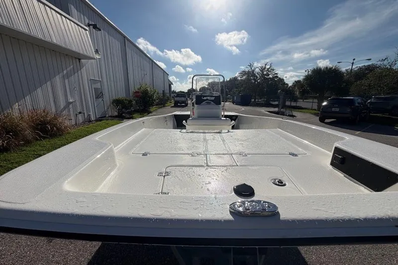 Slide: The Image of 2027 Mako Pro Skiff 17 CC boat, white deck, parked outdoors under a sunny sky. - 5