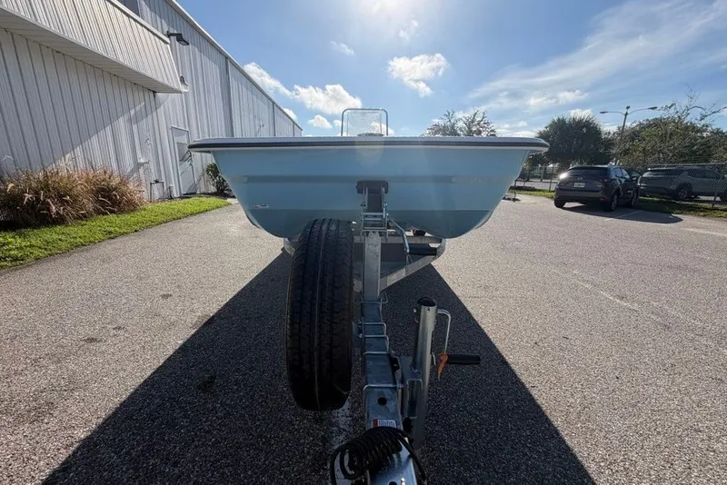 Slide: The Image of 2027 Mako Pro Skiff 17 CC on trailer, parked outdoors under a clear sky. - 4