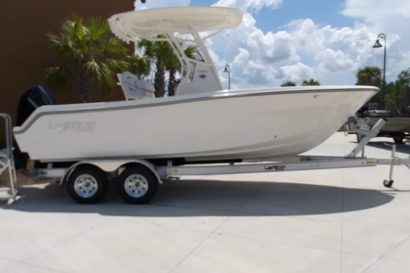 The Image of 2027 Mako 226 Center Console boat on trailer, parked outdoors under a cloudy sky. - 1