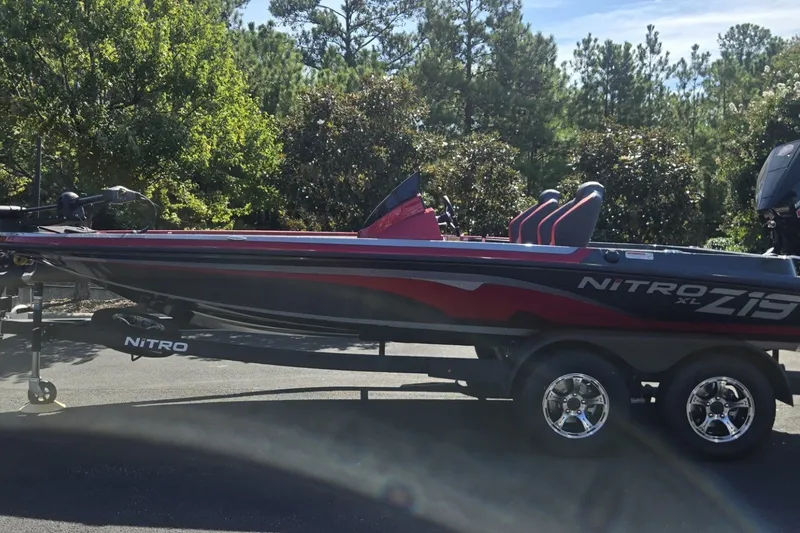 The Image of 2027 Nitro Z19 XL boat on trailer, parked outdoors with trees in background. - 0