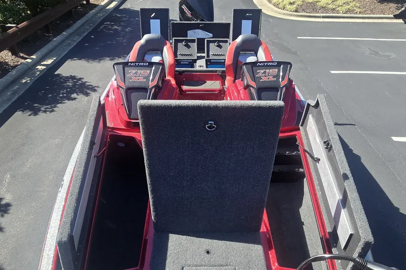 Slide: The Image of 2027 Nitro Z19 XL boat interior with open storage compartments in a parking lot. - 2