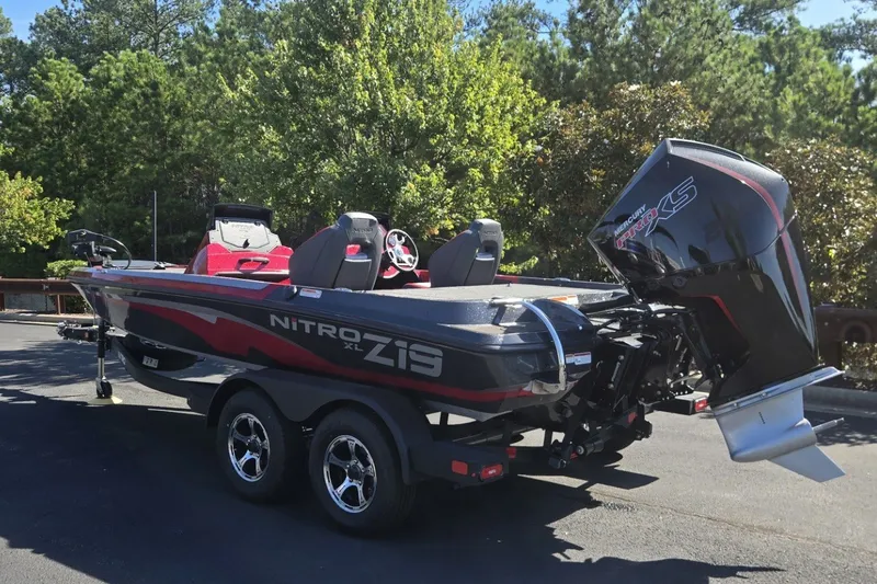 Slide: The Image of 2027 Nitro Z19 XL boat on trailer, parked outdoors with trees in background. - 1