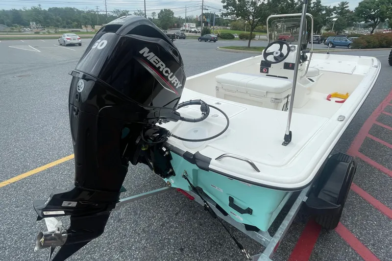 Slide: The Image of 2027 Mako Pro Skiff 17 CC with Mercury outboard motor in parking lot. - 2