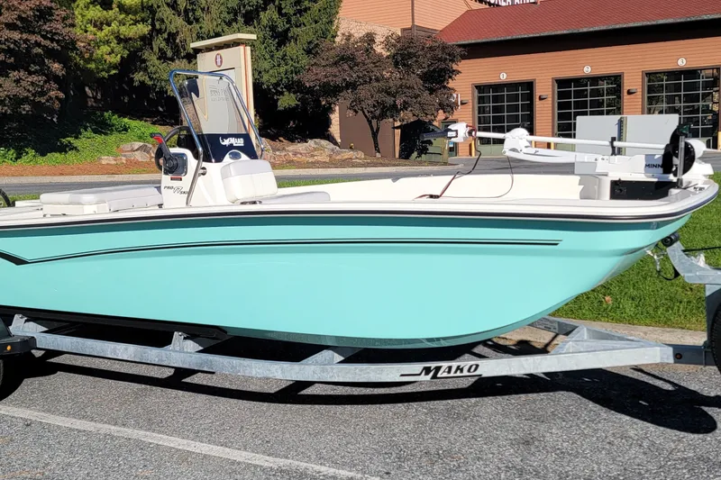 Slide: The Image of 2027 Mako Pro Skiff 17 CC boat on trailer, parked outdoors in sunlight. - 1