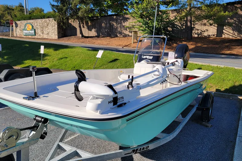 Slide: The Image of 2027 Mako Pro Skiff 17 CC boat on trailer, displayed outdoors. - 2