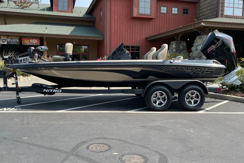 Slide: The Image of 2027 Nitro Z19 XL boat on trailer, parked outside a rustic building. - 5