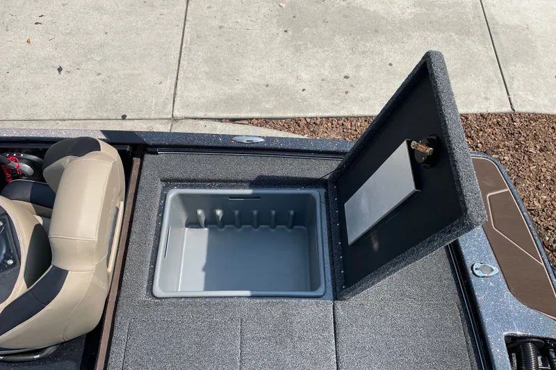 Slide: The Image of 2027 Nitro Z19 XL boat storage compartment with open lid, next to beige seat. - 16