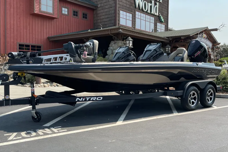 Slide: The Image of 2027 Nitro Z19 XL boat on trailer outside a rustic building. - 6