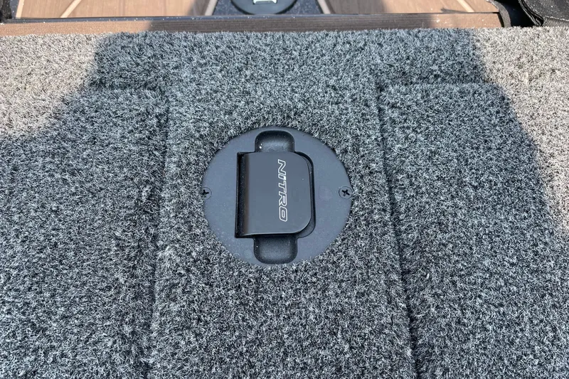 Slide: The Image of Carpeted deck of 2027 Nitro Z19 XL boat with branded latch. - 18