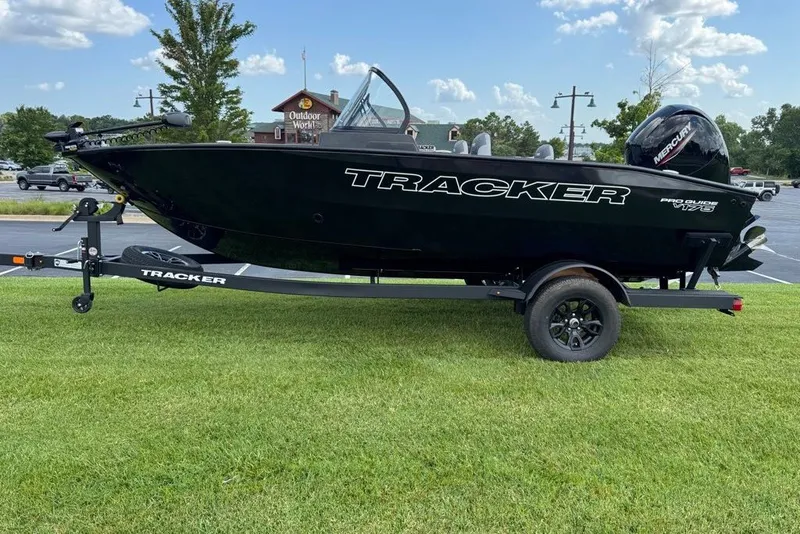 The Image of 2027 Tracker Pro Guide V-175 WT boat on trailer, parked on grass, under a clear sky. - 0