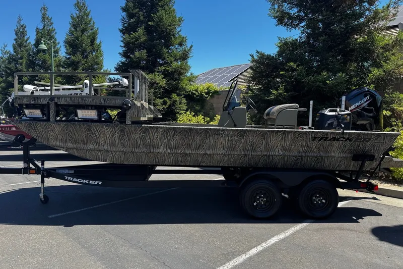The Image of 2027 Tracker Grizzly 2072 CC Sportsman boat on trailer, parked outdoors. - 0