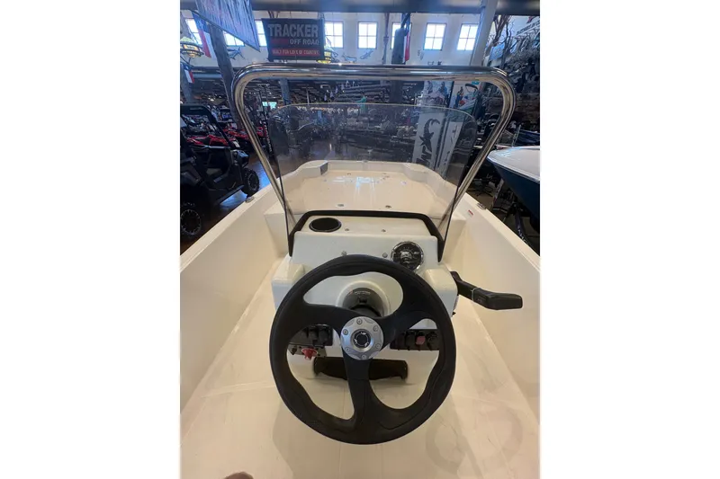 Slide: The Image of 2027 Mako Pro Skiff 17 CC boat console with steering wheel and controls. - 17