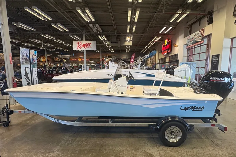 Slide: The Image of 2027 Mako Pro Skiff 17 CC boat displayed indoors on a trailer. - 6