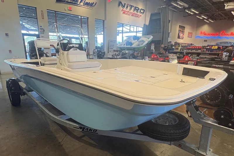 Slide: The Image of 2027 Mako Pro Skiff 17 CC boat displayed in a showroom. - 2