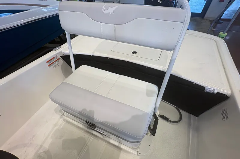 Slide: The Image of 2027 Mako Pro Skiff 17 CC boat interior with white seating and storage compartment. - 16