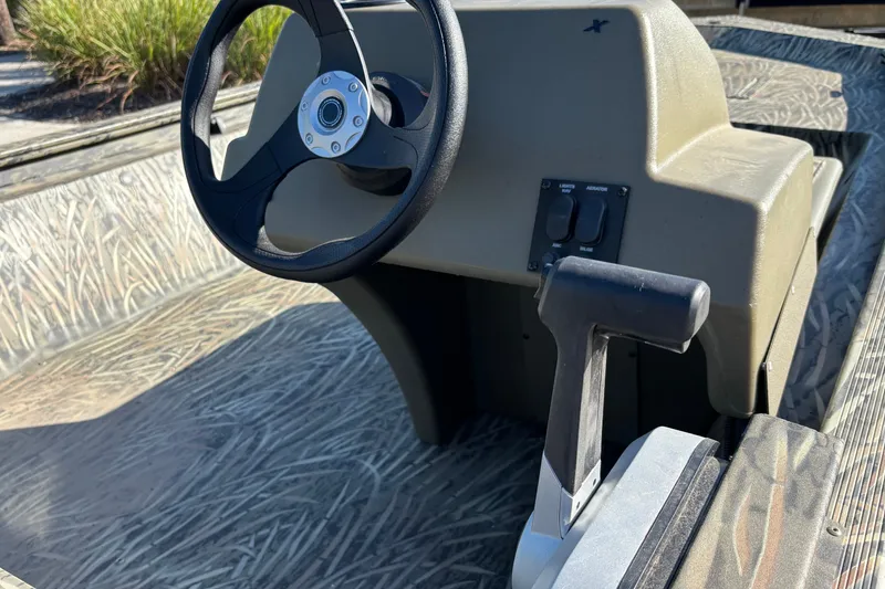 Slide: The Image of 2027 Tracker Grizzly 1648 SC boat console with steering wheel and throttle control. - 33