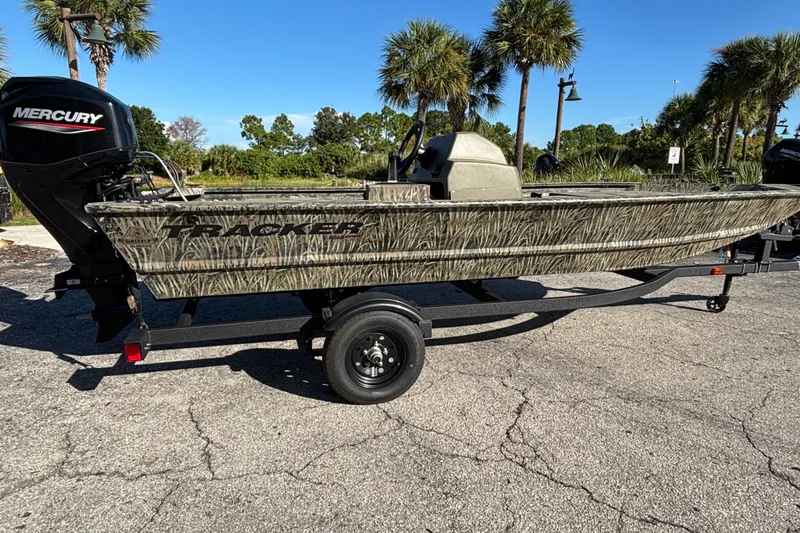 The Image of 2027 Tracker Grizzly 1648 SC boat with Mercury engine on trailer, parked outdoors. - 0