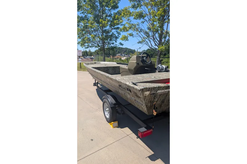 Slide: The Image of 2027 Tracker Grizzly 1648 SC boat on trailer, camo design, sunny day. - 14