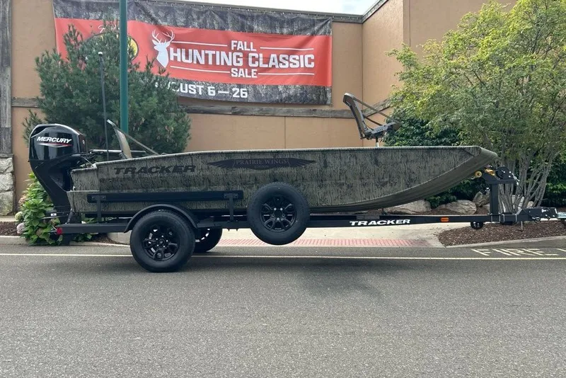 The Image of 2027 Tracker Grizzly 1650 T Prairie Wings Edition boat on trailer, outdoor hunting sale backdrop. - 0