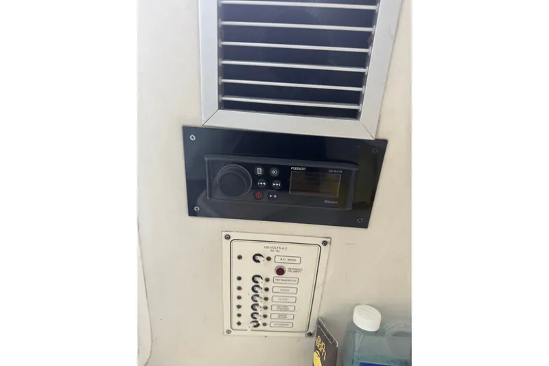 Slide: The Image of 2004 Century 2600 Walk-Around boat control panel with Fusion stereo system and switches. - 27