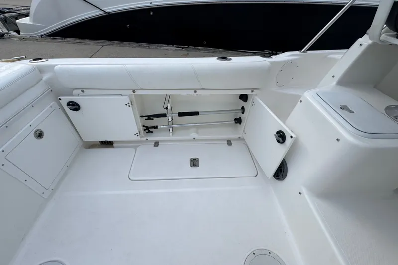 Slide: The Image of 2004 Century 2600 Walk-Around boat interior with open storage compartments and white seating. - 16