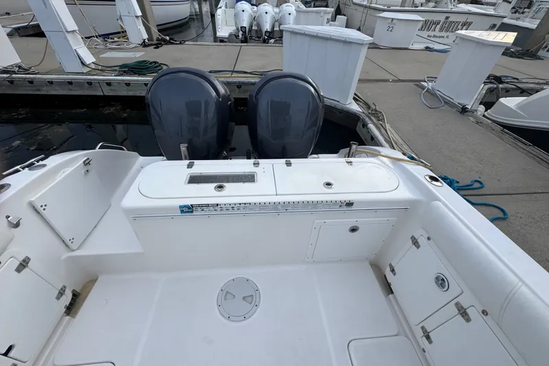 Slide: The Image of 2004 Century 2600 Walk-Around boat with dual outboard motors docked at marina. - 19