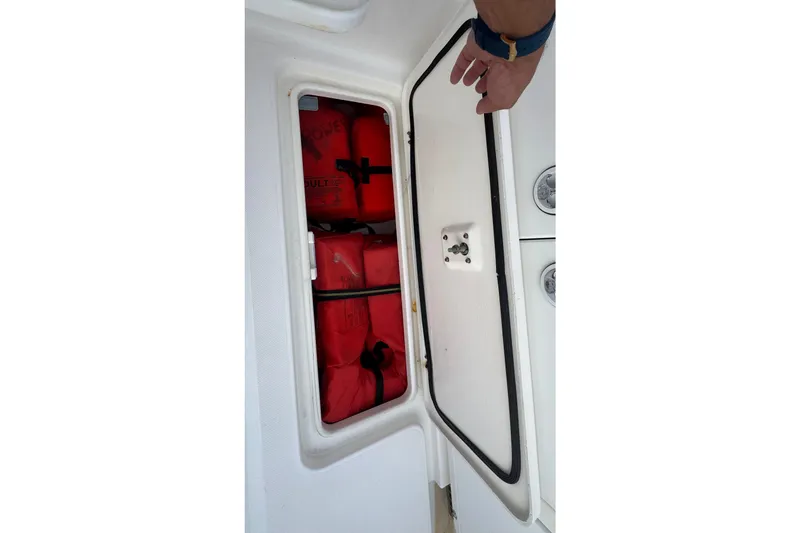 Slide: The Image of Open storage compartment with red life jackets on a 2004 Century 2600 Walk-Around boat. - 14