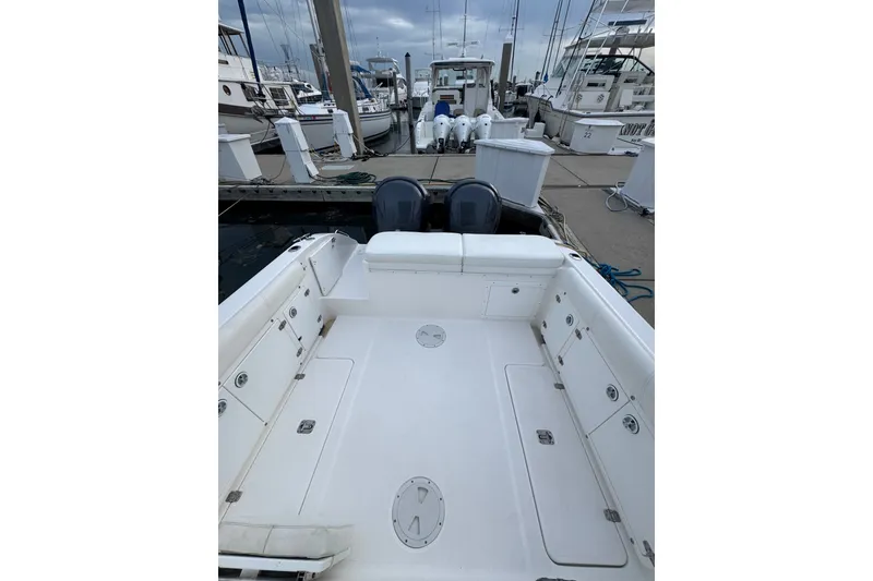 Slide: The Image of 2004 Century 2600 Walk-Around boat docked at marina, showcasing spacious deck and seating. - 13
