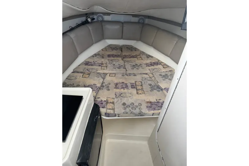 Slide: The Image of 2004 Century 2600 Walk-Around cabin interior with cushioned seating and patterned bedding. - 8