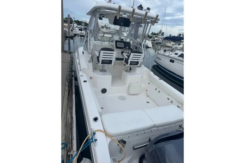Slide: The Image of 2004 Century 2600 Walk-Around boat docked at marina, featuring spacious deck and seating. - 3