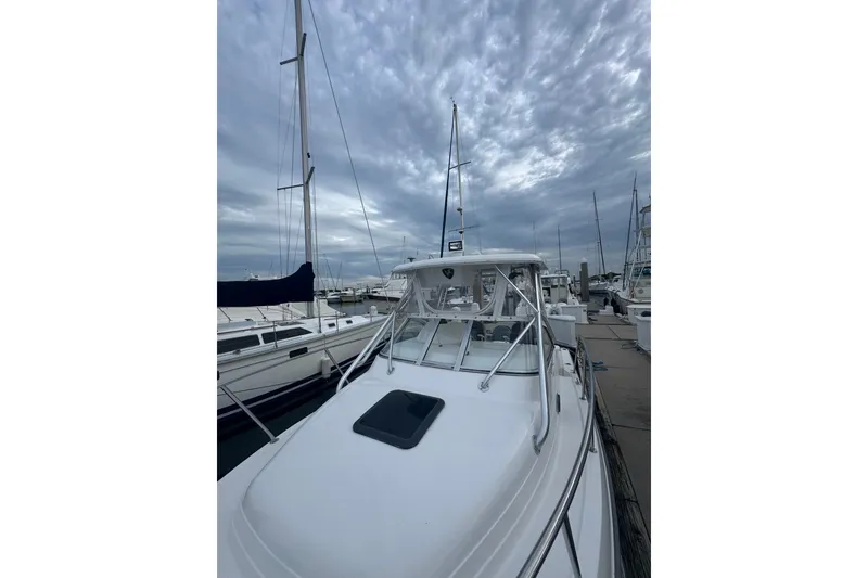 Slide: The Image of 2004 Century 2600 Walk-Around boat docked under cloudy skies. - 4