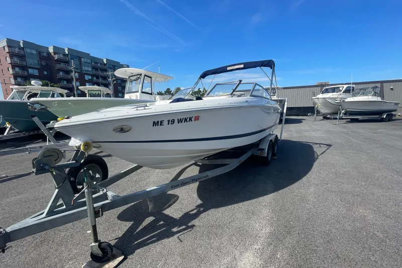 The Image of 2008 Cobalt 202 boat on trailer in parking lot, clear blue sky background. - 0