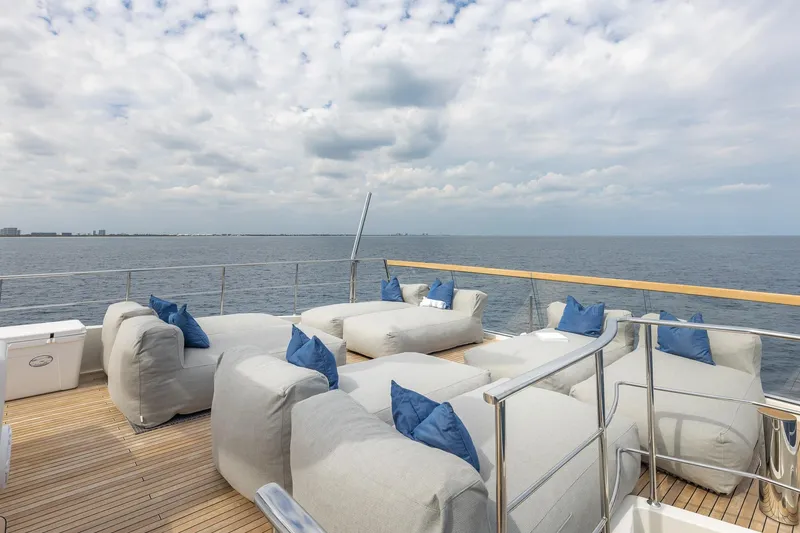 Slide: The Image of Luxurious Sanlorenzo SD112 yacht deck with plush seating, ocean view, and cloudy sky, 2019 model. - 59