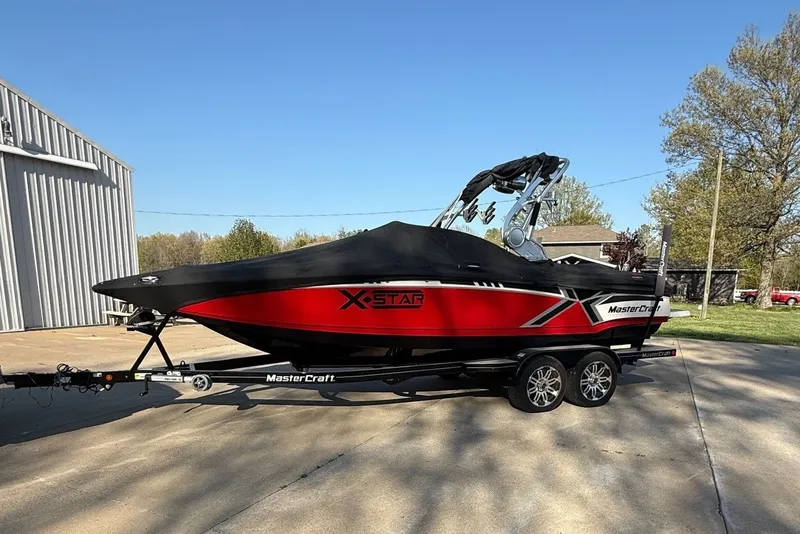 The Image of A red 2013 MasterCraft XStar boat on a trailer. - 0