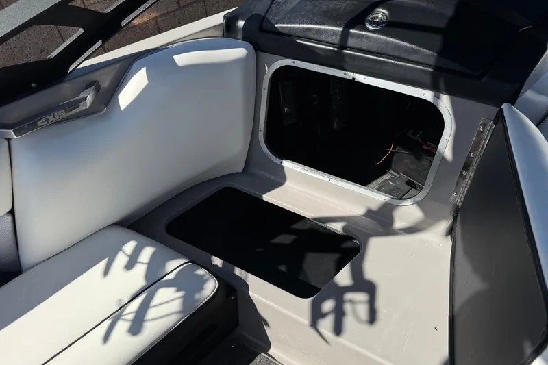Slide: The Image of Interior of a 2011 Axis A22 boat showing storage compartment and seating area. - 25