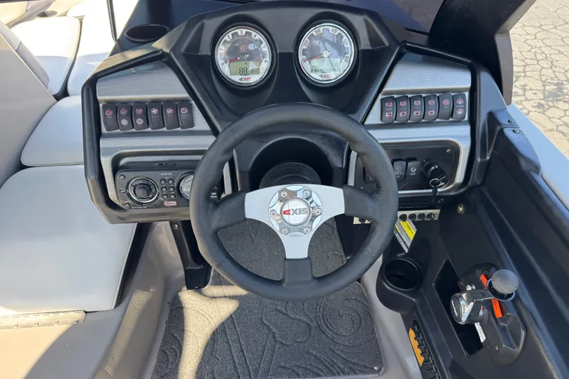 Slide: The Image of 2011 Axis A22 boat dashboard with steering wheel and control panel. - 28