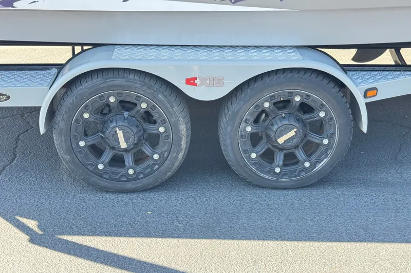 Slide: The Image of Trailer wheels of a 2011 Axis A22 boat on asphalt pavement. - 32