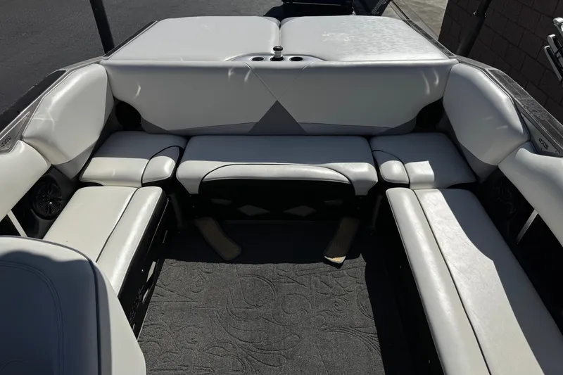 Slide: The Image of 2011 Axis A22 boat interior with white cushioned seating and carpeted floor. - 20