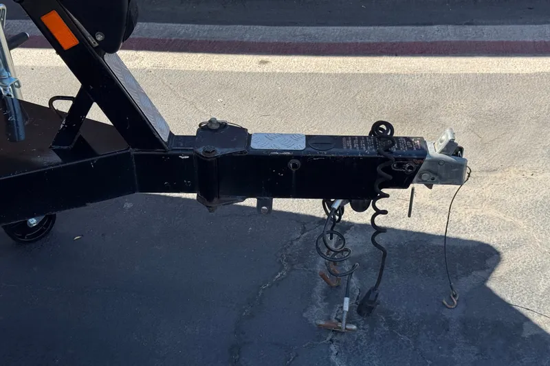 Slide: The Image of Trailer hitch of a 2011 Axis A22 on pavement, showing safety chains and coupler. - 33
