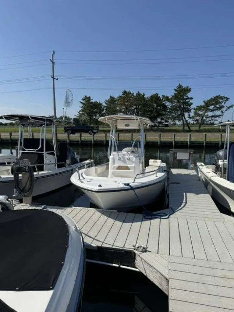 Slide: The Image of A 2023 Edgewater 188CC boat is docked, surrounded by other boats. - 1