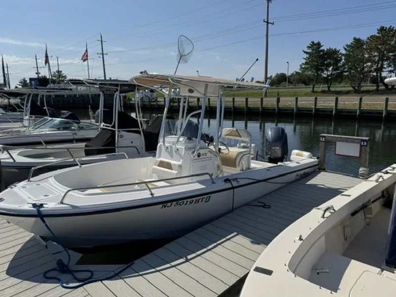Slide: The Image of A 2023 Edgewater 188CC boat docked. It features a white deck and an outboard motor. - 7